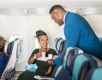 Steward qui apporte du jus à une cliente 